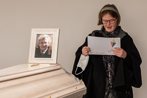Ilja Verstraten afscheidsfotograaf en uitvaartfotograaf maakte een foto van een vrouw met een verstandelijke beperking die een gedicht voorleest op de begrafenis van haar oma in België